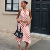 Pink polka dot halter crop top and asymmetric midi skirt.
