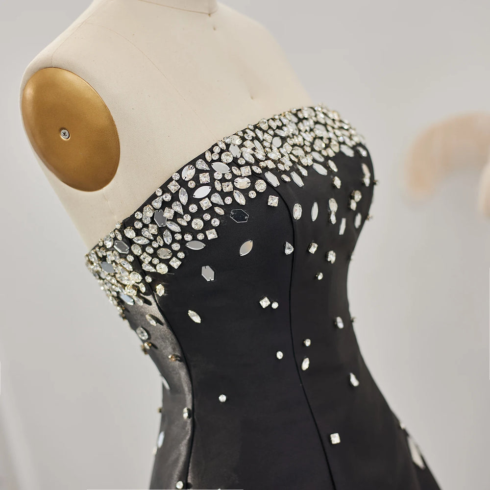 Black dress with silver embellishments on a mannequin against a neutral background
