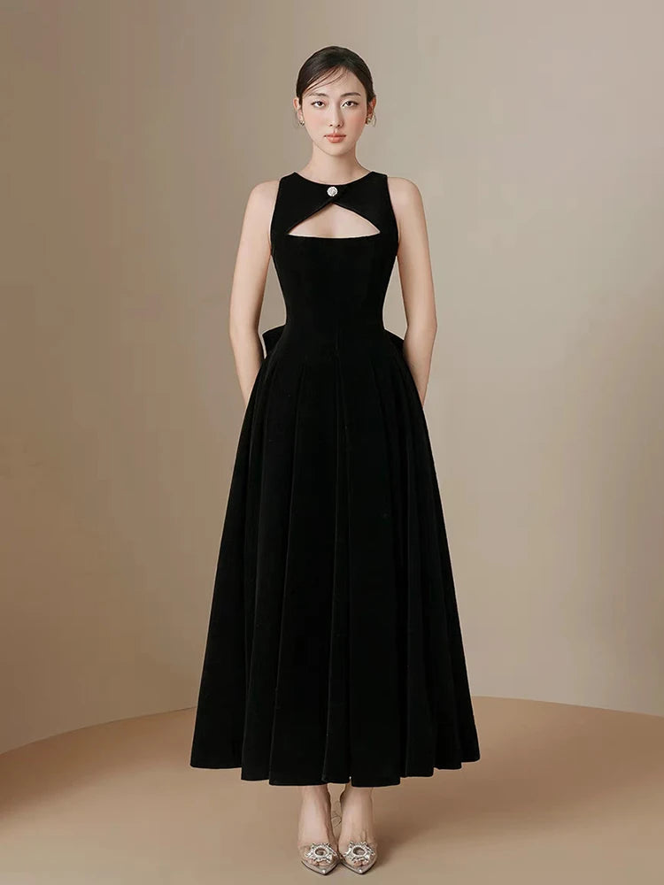 Woman wearing a black evening gown against a beige background