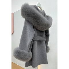 Gray coat with fur trim on a hanger against a white background