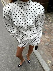 Person wearing a polka dot dress on a street