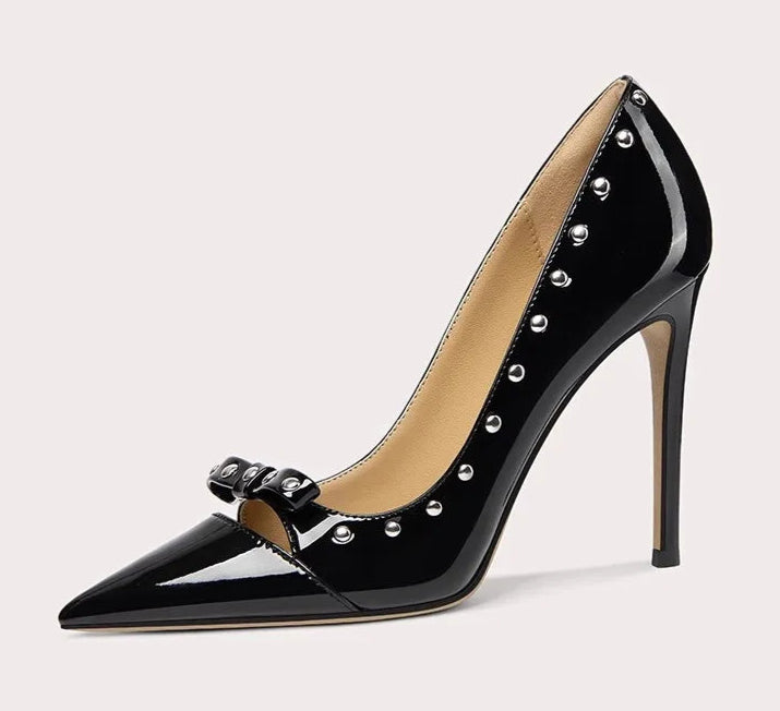 Black high-heeled shoe with studded details on a light gray background