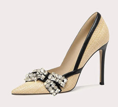 High-heeled shoe with decorative strap on a light gray background