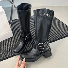 Black knee-high boots with buckles on a textured mat