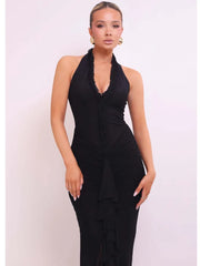 Woman wearing a black halter neck dress against a light pink background