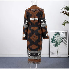 Mannequin wearing a patterned dress with a white wall and framed picture in the background