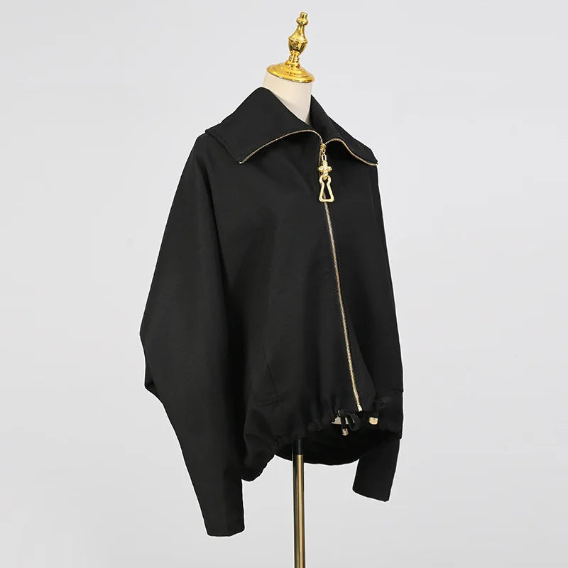 Black jacket with gold zipper on a mannequin against a gray background