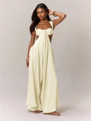 A woman wearing a strapless, long, white jumpsuit against a plain background