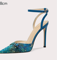 Blue high-heeled shoe with a patterned sole on a light gray background