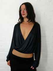 Model wearing a black Deep V-neck Draped Crop Top