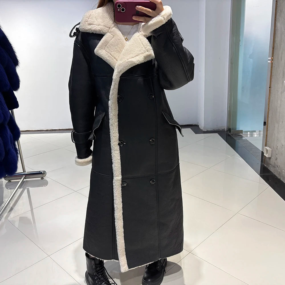 Person wearing a long black coat with white fur trim in a store setting.
