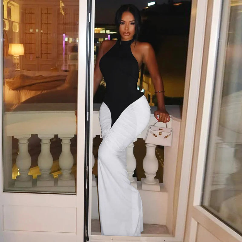 Woman in black top and white pants standing in a doorway.