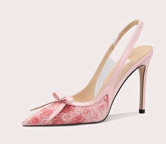 Pink high-heeled shoe with floral design and bow on a white background