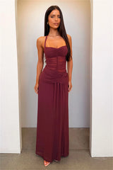 Woman wearing a burgundy evening gown against a plain background