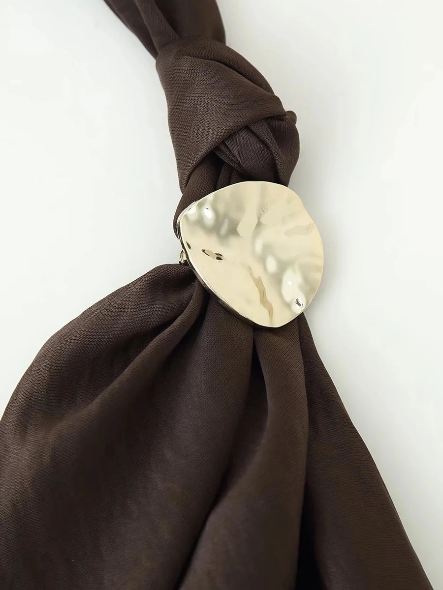 Brown fabric tied with a gold circular knot holder