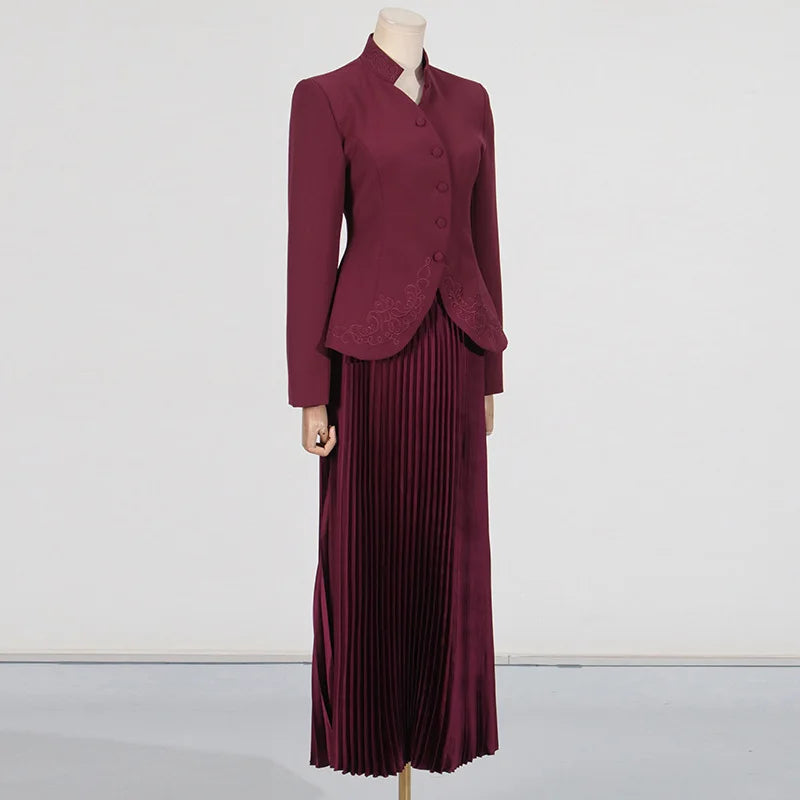 Maroon suit with a jacket and pleated skirt on a mannequin against a white background