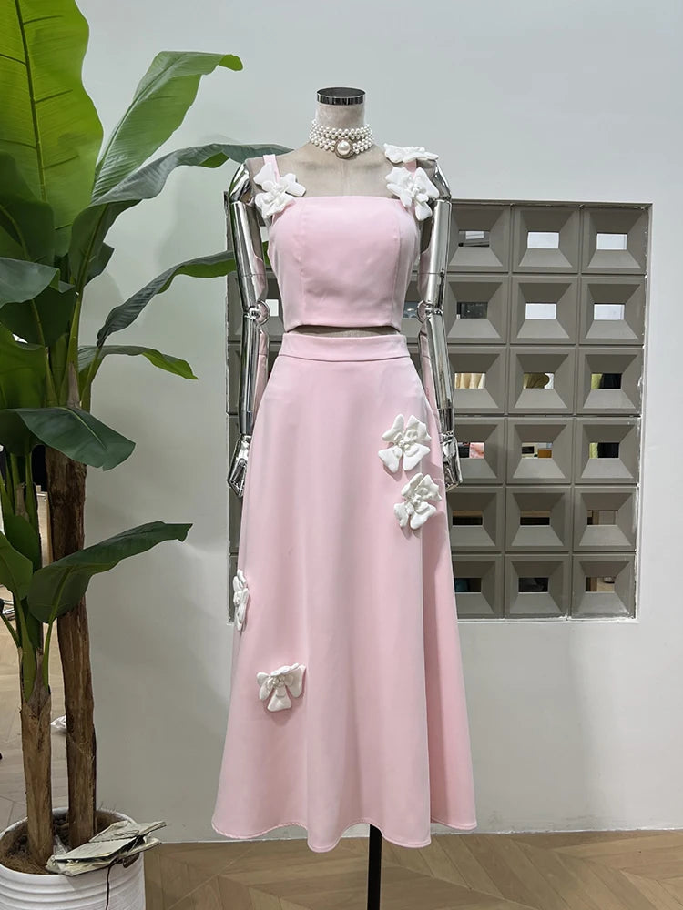 Pink dress on a mannequin with floral details against a geometric wall.
