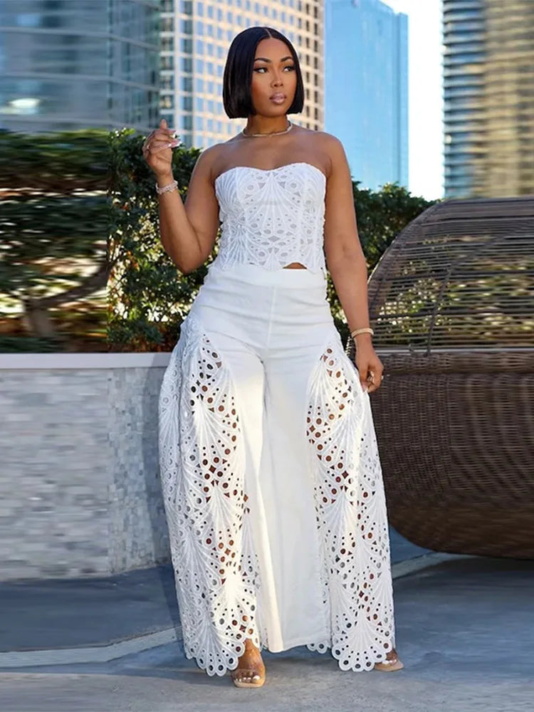 Woman in a white outfit with lace details standing outdoors with buildings in the background