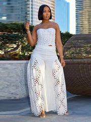 Woman in a white outfit with lace details standing outdoors with buildings in the background