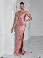 Woman in a Pink evening gown standing in an elegant interior setting.