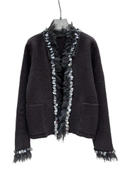 Black textured sweater with decorative fringes on a white background