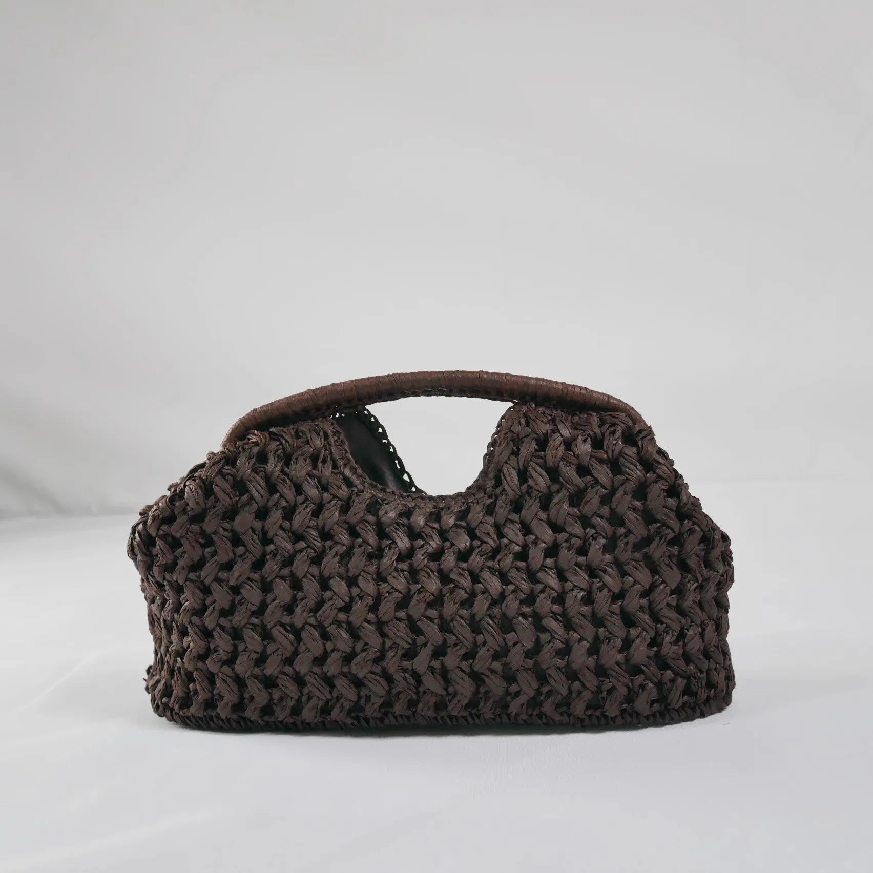 Brown woven handbag on a light gray background