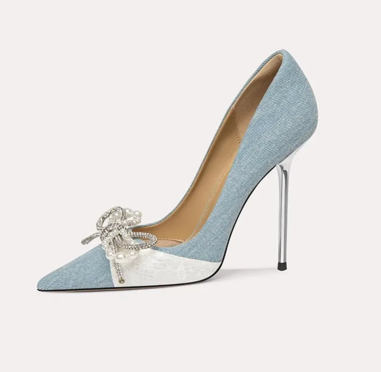 Blue high-heeled shoe with decorative bow on a white background