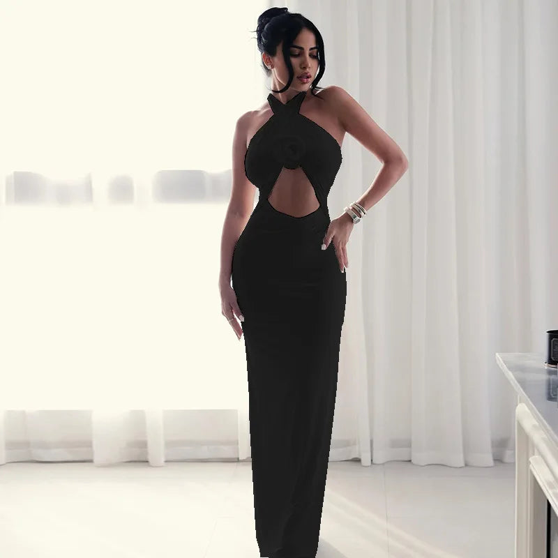 Woman in a black evening gown standing in a room with white curtains.