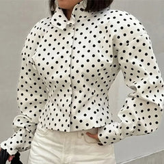 White blouse with black polka dots worn by a person against a neutral background