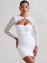 White dress with sheer sleeves worn by a model on a plain background
