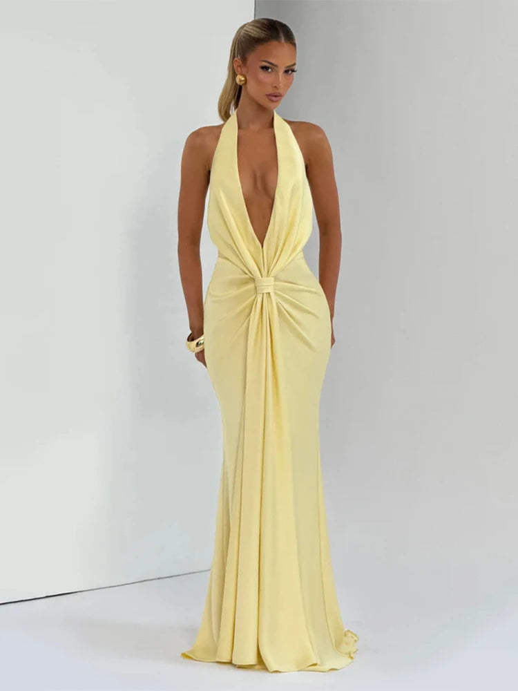 Woman wearing a light yellow evening gown with a plunging neckline on a white background