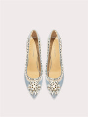 Pair of light blue high-heeled shoes with decorative embellishments on a white background