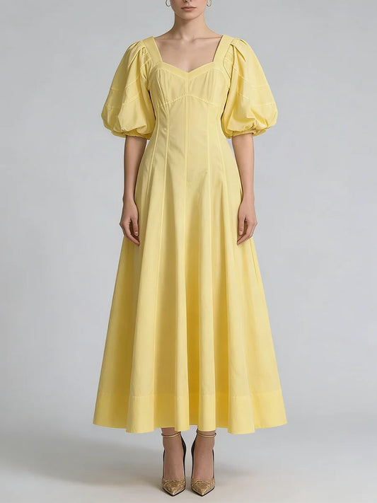 Yellow dress with puff sleeves on a plain background