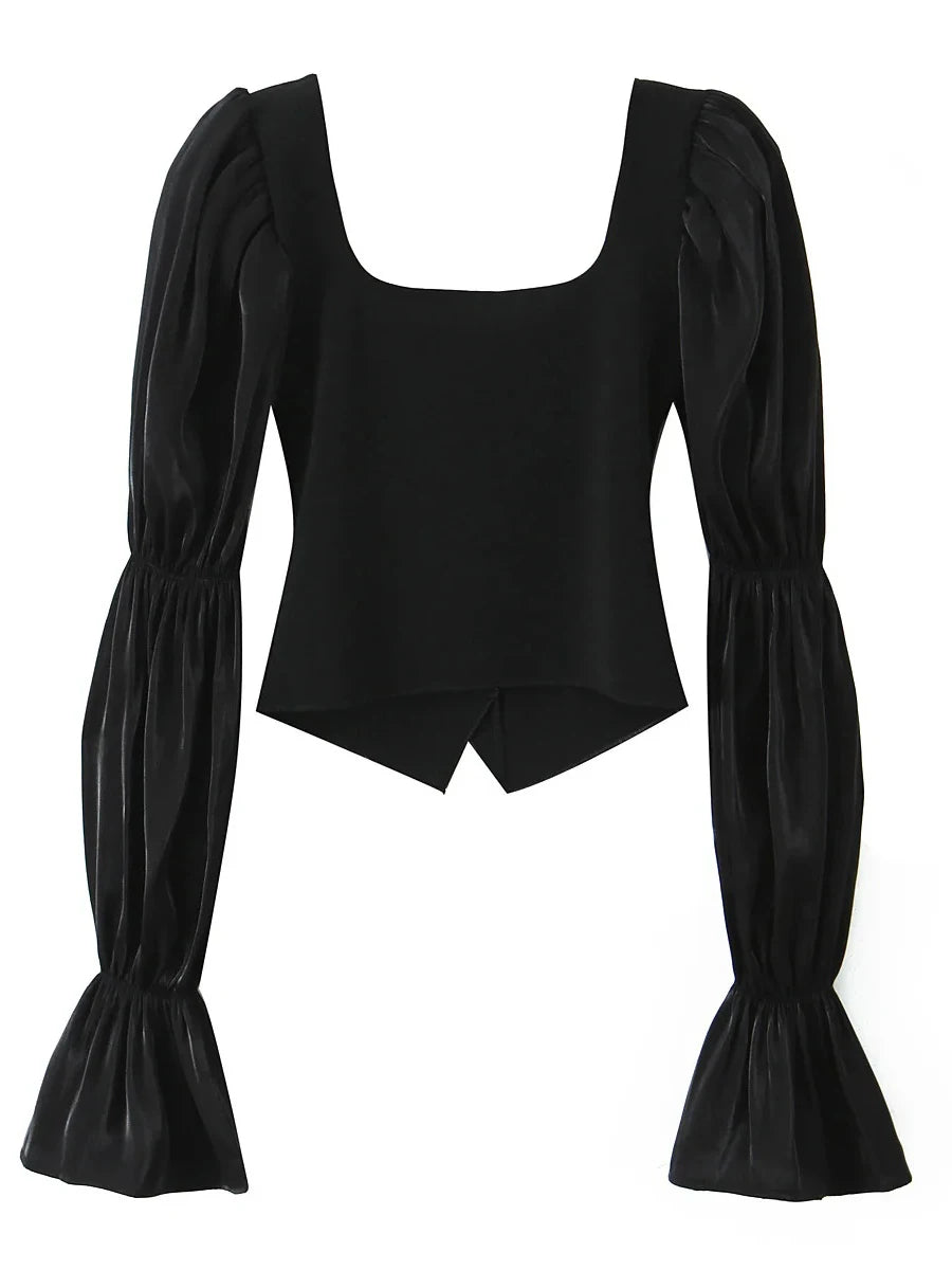 Black top with puffed sleeves on a white background
