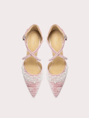 Pair of pink high-heeled shoes with beaded details on a light gray background