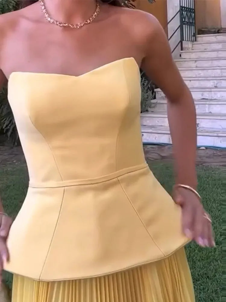 Yellow strapless dress worn by a person outdoors.