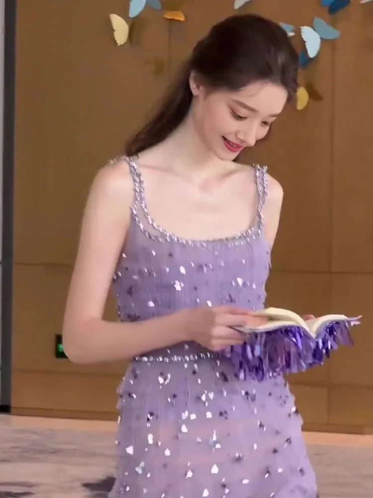 Woman in a purple sequin dress reading a book with colorful butterfly decorations in the background