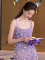 Woman in a purple sequin dress reading a book with colorful butterfly decorations in the background
