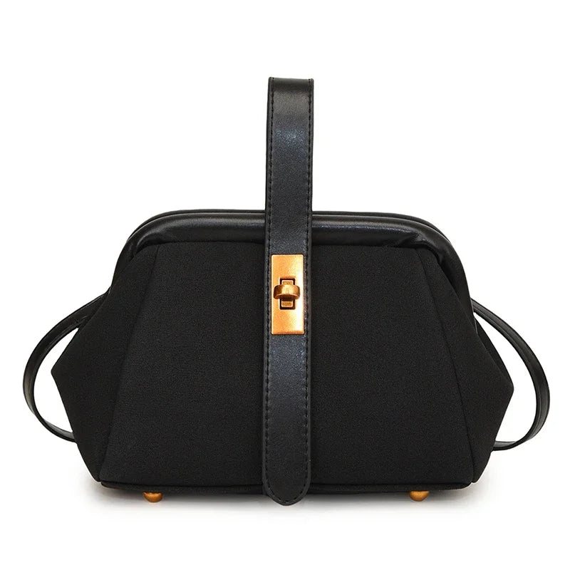 Black handbag with gold accents on a white background