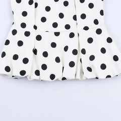 White fabric with black polka dots on a light gray background