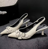 White pointed-toe slingback heels with silver buckle accents