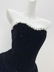 Black strapless dress with decorative neckline on a mannequin against a white background
