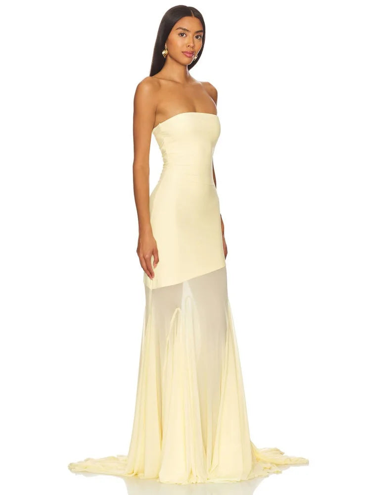 Woman wearing a strapless yellow evening gown on a white background