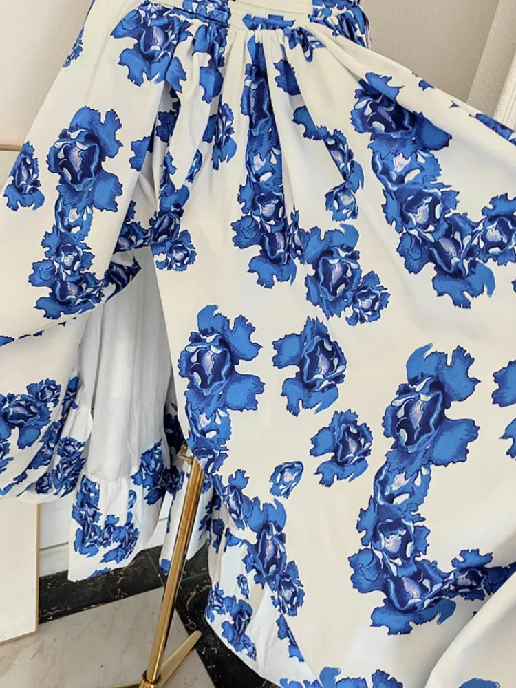 White fabric with blue floral pattern draped over a chair.