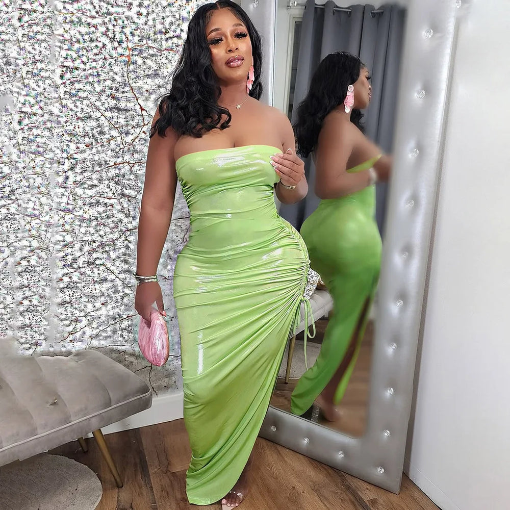 Woman in a green strapless dress standing in front of a mirror.