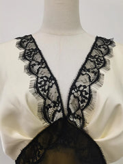 Mannequin wearing a white garment with black lace detailing