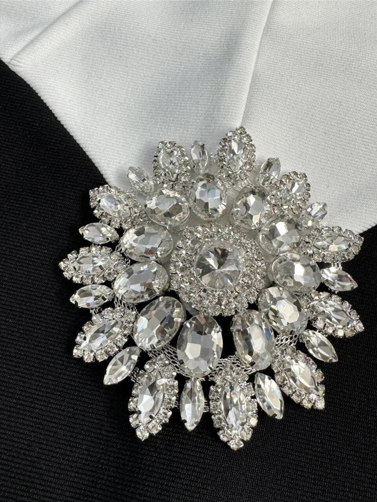 Elegant brooch with crystal details on a black and white fabric background