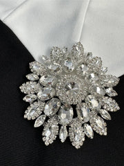 Elegant brooch with crystal details on a black and white fabric background