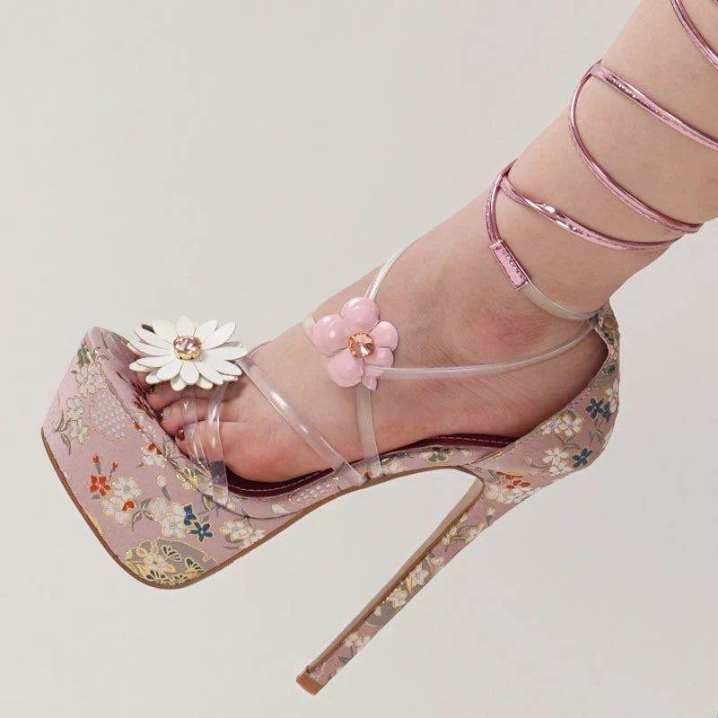 Pink floral high-heeled shoes with decorative flowers on a light background