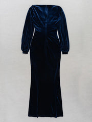 Navy velvet dress with long sleeves on a light gray background